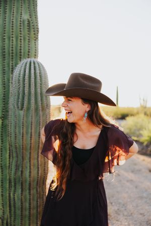 Joyful movement captured between towering saguaros in western-styled desert portrait.