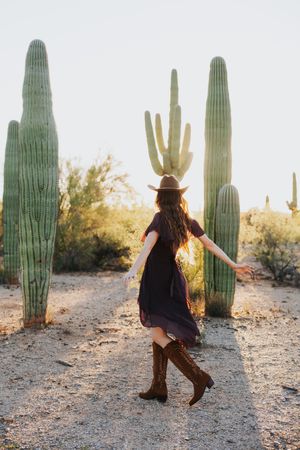 Playful dancing movements captured in desert landscape with towering saguaros.