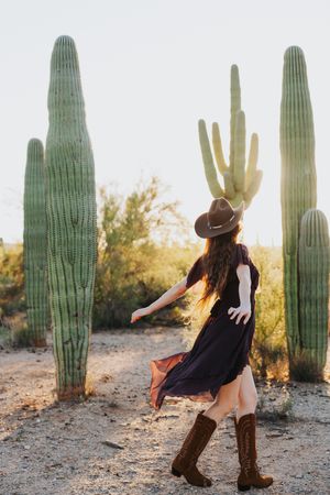 Dynamic desert photoshoot featuring western-inspired poses among saguaro cacti.