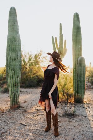 Artistic desert portrait series with flowing black dress and cowboy boots.