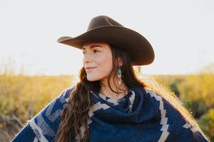 A western fashion shoot featuring a blue poncho and cowboy hat among desert scenery.