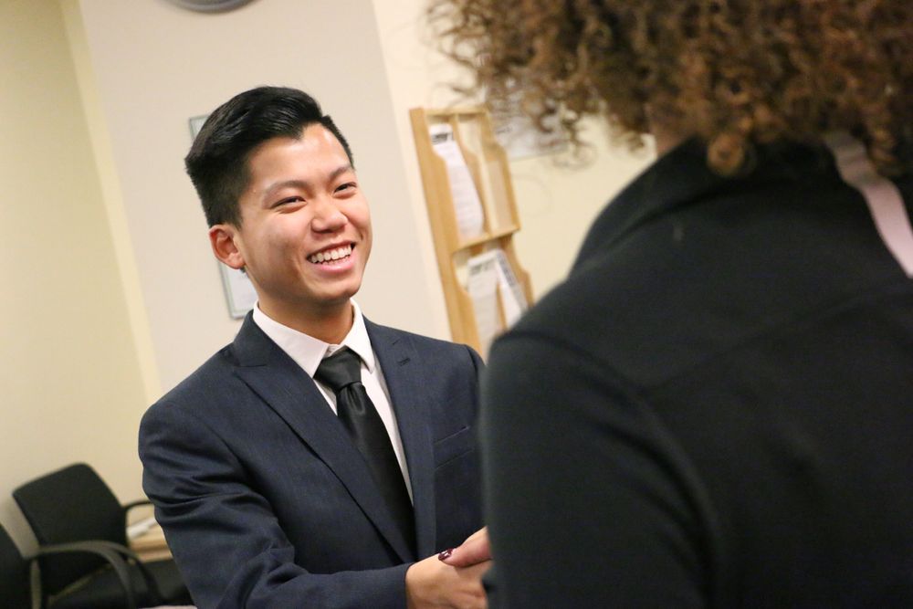 Professional in a suit and tie smiling warmly during a business conversation.