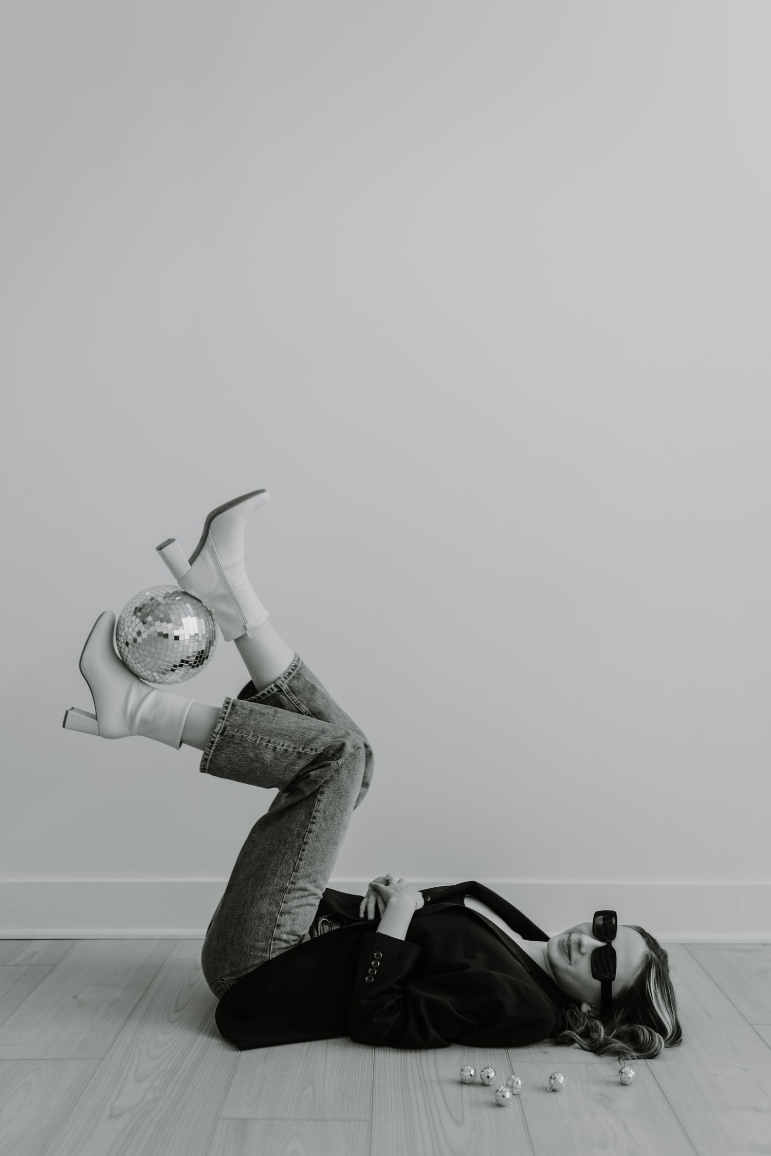 Artistic black and white photo series of person lying on floor against white background.