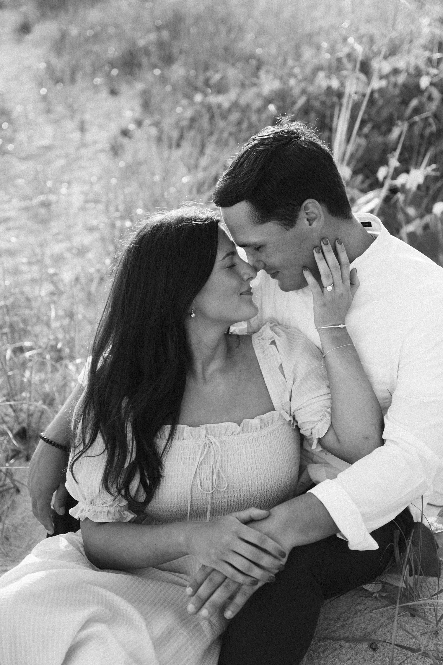 Smiling engaged couple pauses for an embrace during their Brooklyn, NY engagement session