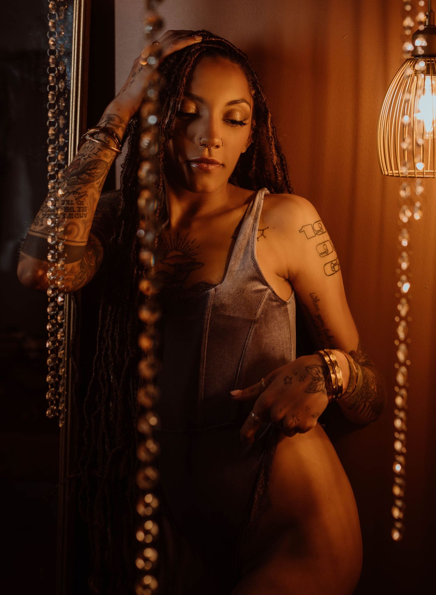 Artistic boudoir portrait with hanging crystal lights creating a romantic and moody atmosphere in Hudson, Wisconsin.
