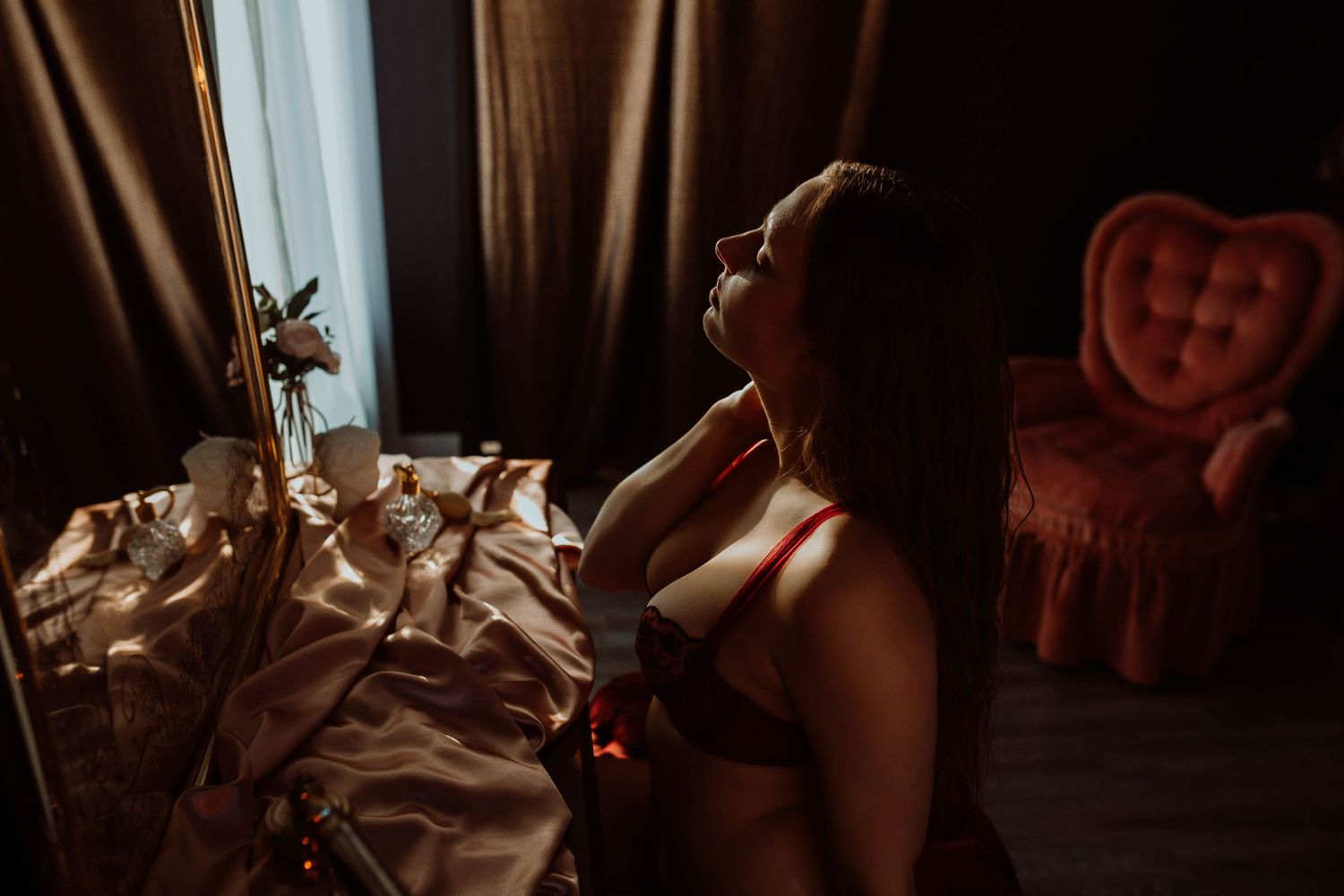 Moody boudoir photographer with vintage furniture and dramatic window lighting Minnesota.