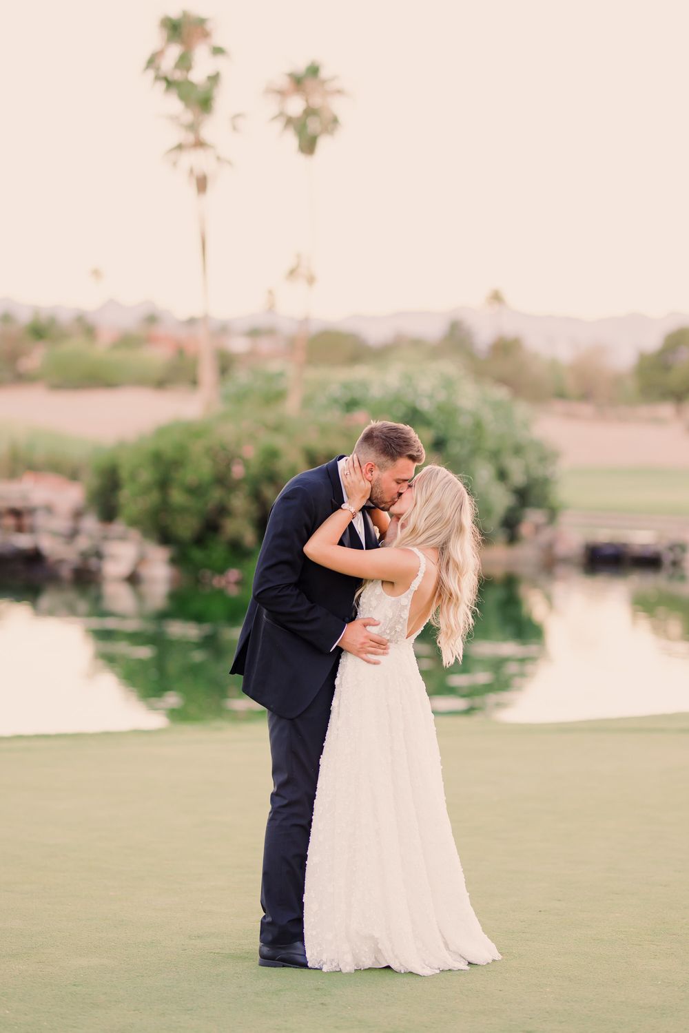 CANYON GATE COUNTRY CLUB WEDDING IN LAS VEGAS, couple shares a romantic moment on a golf course at sunset with palm trees