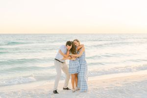 Couple sharing tender moments together on a pristine white sand beach at sunset.