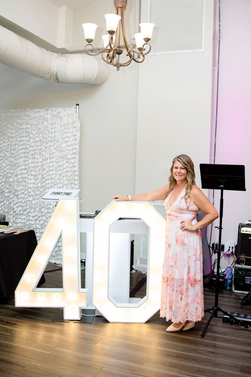 Large white illuminated 40 numbers serve as dramatic decor pieces in a modern studio space with hardwood floors.