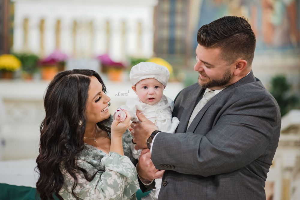 Parents sharing a joyful moment with their baby during a special ceremony.