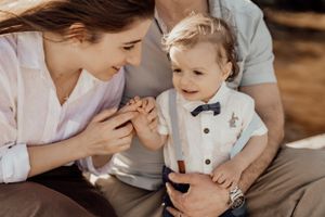 A tender moment captured between parent and toddler in formal wear with a bow tie.