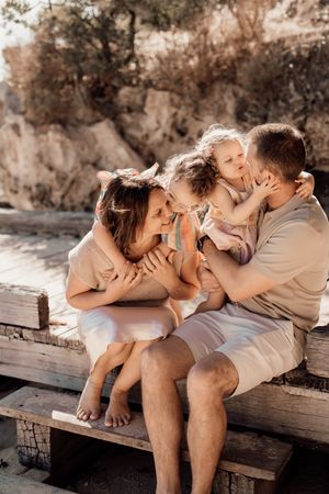 A romantic montage of an affectionate couple sitting together on a rustic wooden bench in a dreamy sepia-toned setting.