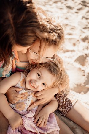 People enjoying a warm sunny day at the beach, sharing laughter and playful moments in the sand.