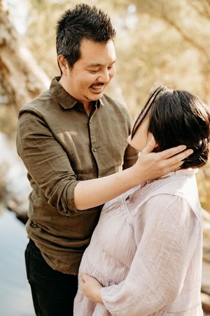 A romantic couple in brown and pink outfits share tender moments in a series of outdoor engagement photos.
