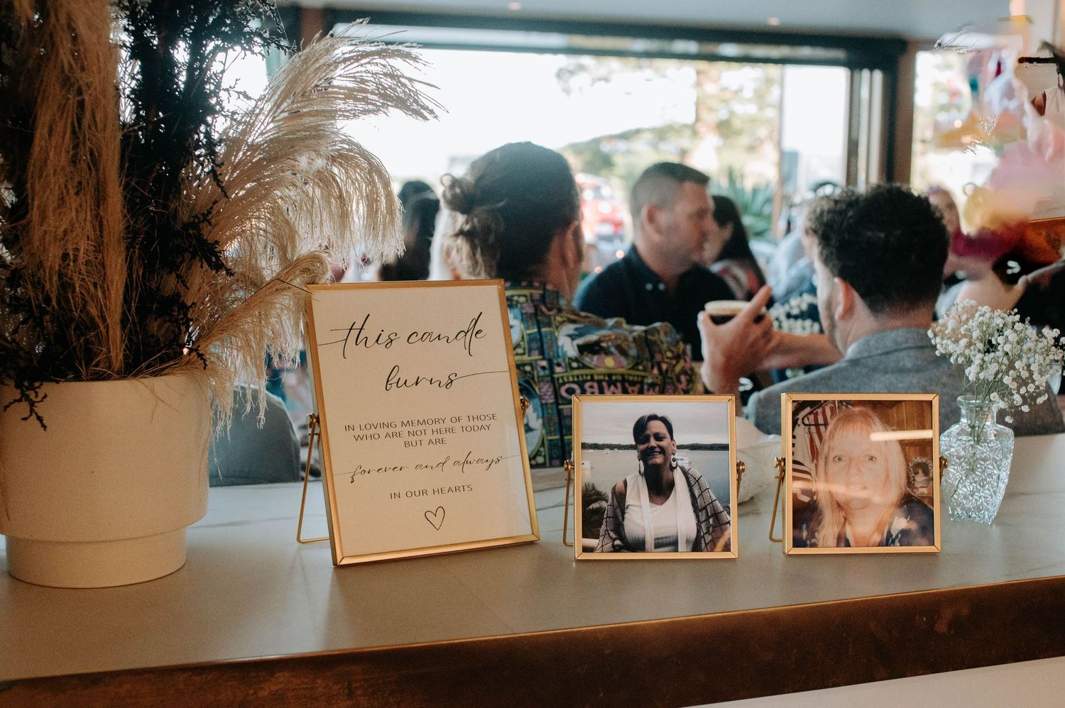 A wedding memorial display featuring framed photos and decorative elements on a wooden table.