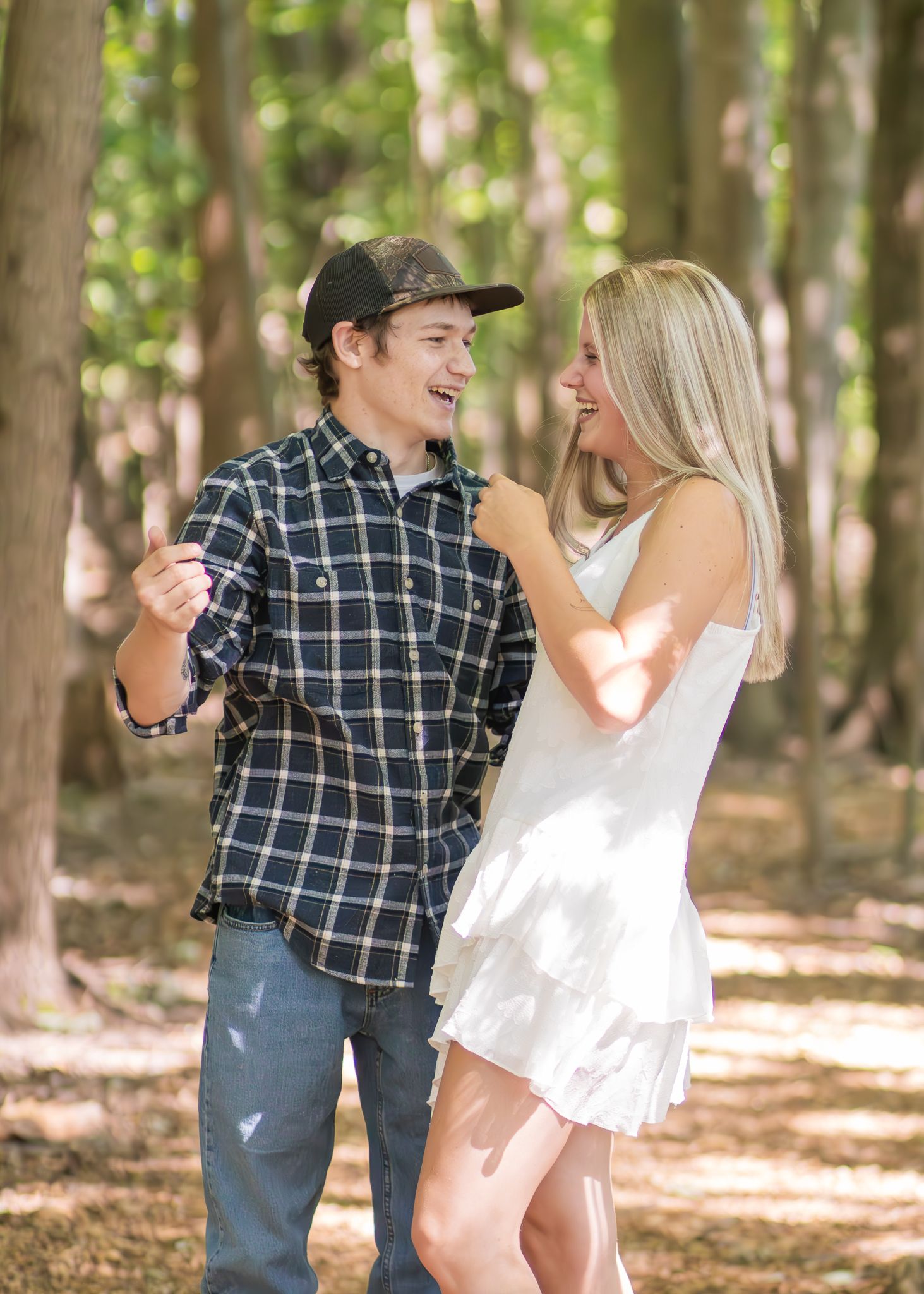 Happy couple in a wooded area sharing a joyful moment together on a sunny day.