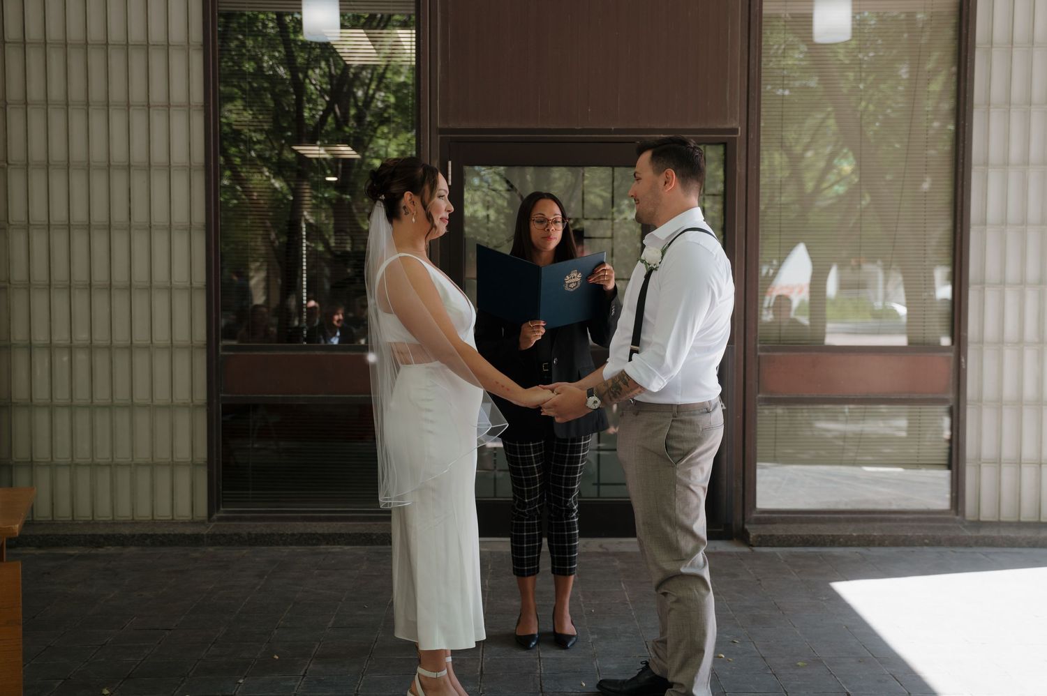 Bride and groom exchange vows with officiant during intimate outdoor wedding ceremony.