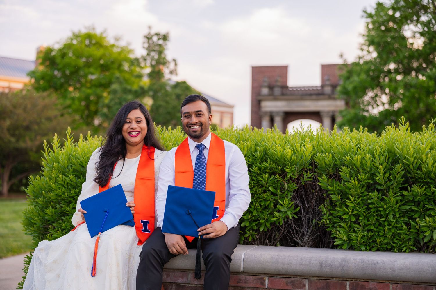 Cute couple smiling and laughing beside each other sitting in front of Hallene Gateway