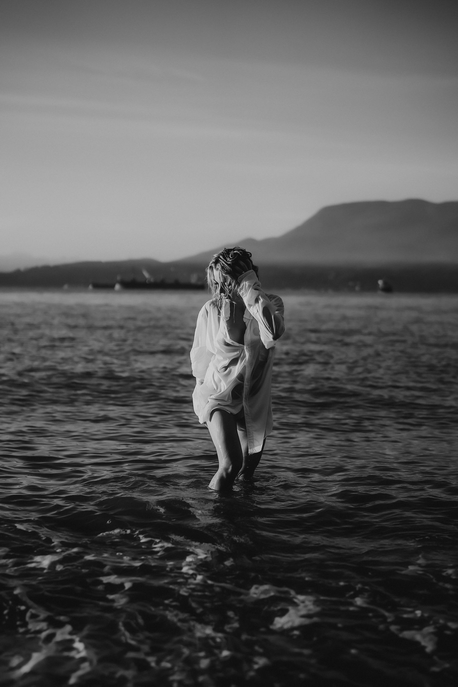 Black and white photo of a lady coming out from the ocean in Vancouver