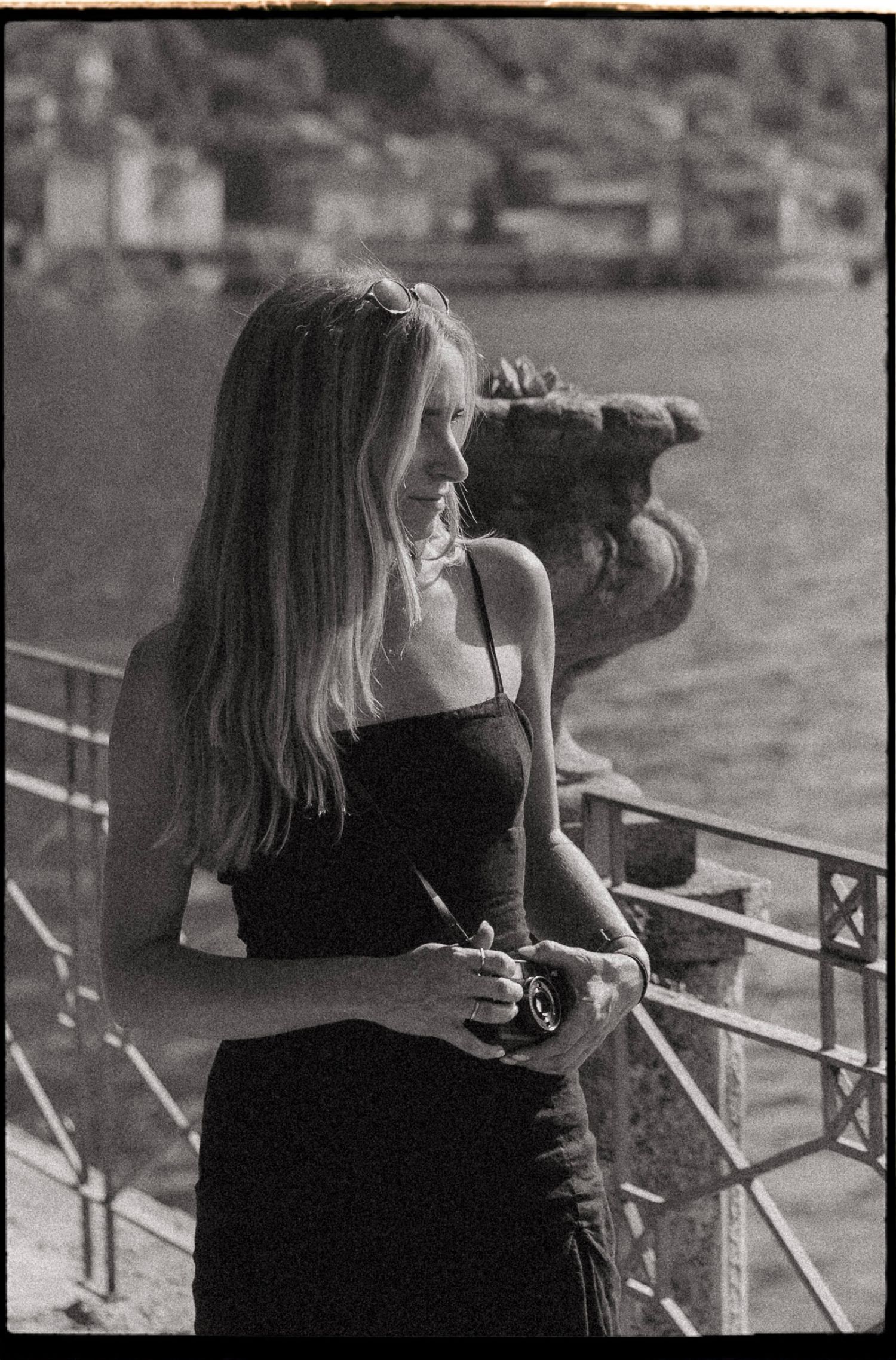 A series of black and white photographs showing someone taking pictures from a balcony or railing.