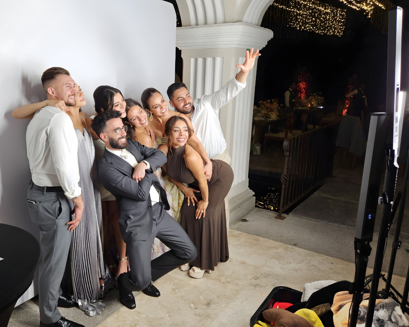 A group of people pose together in a photo booth, taking multiple fun and candid shots in sequence.