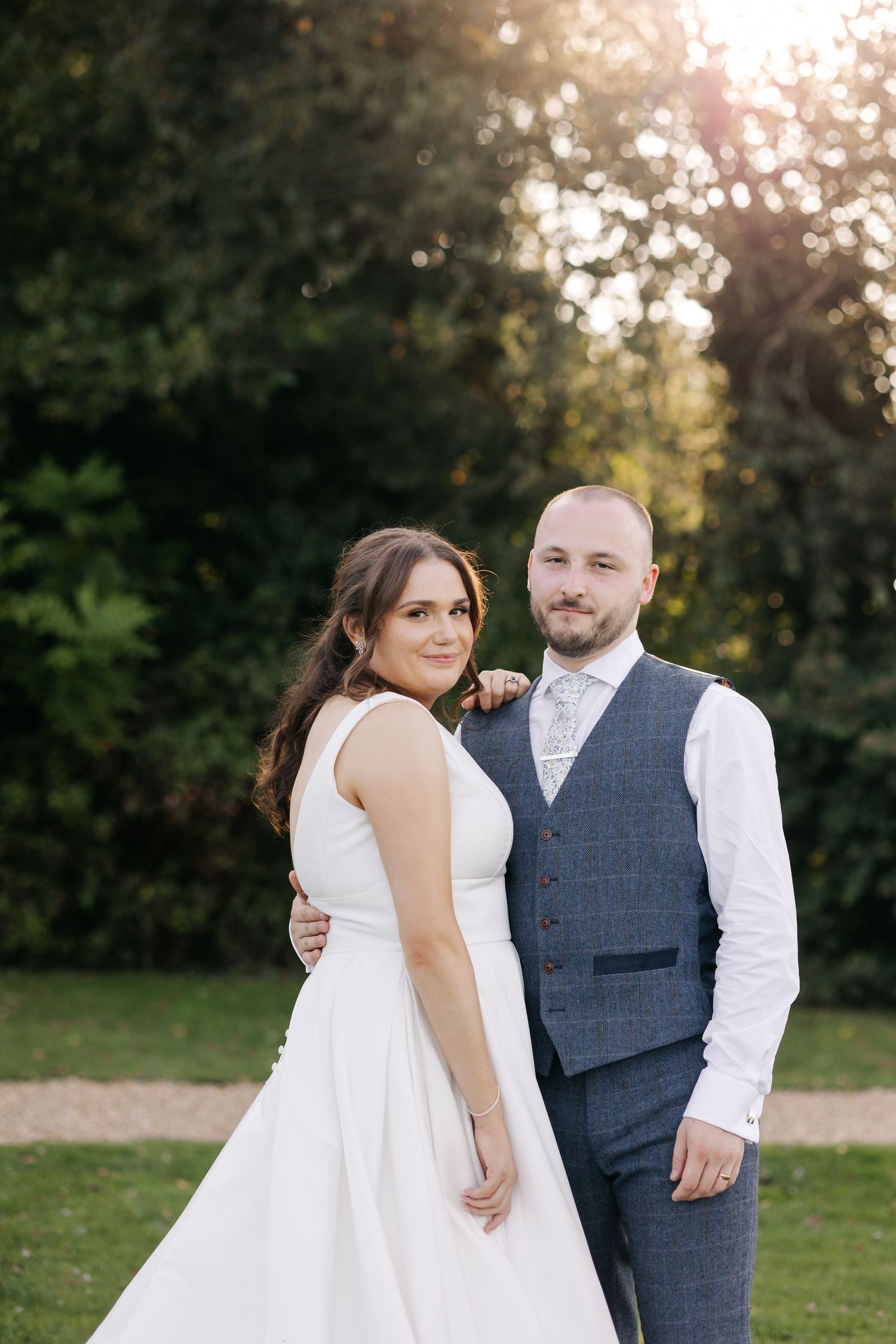 A romantic outdoor wedding photoshoot sequence showing a couple posing together at sunset in a natural setting.