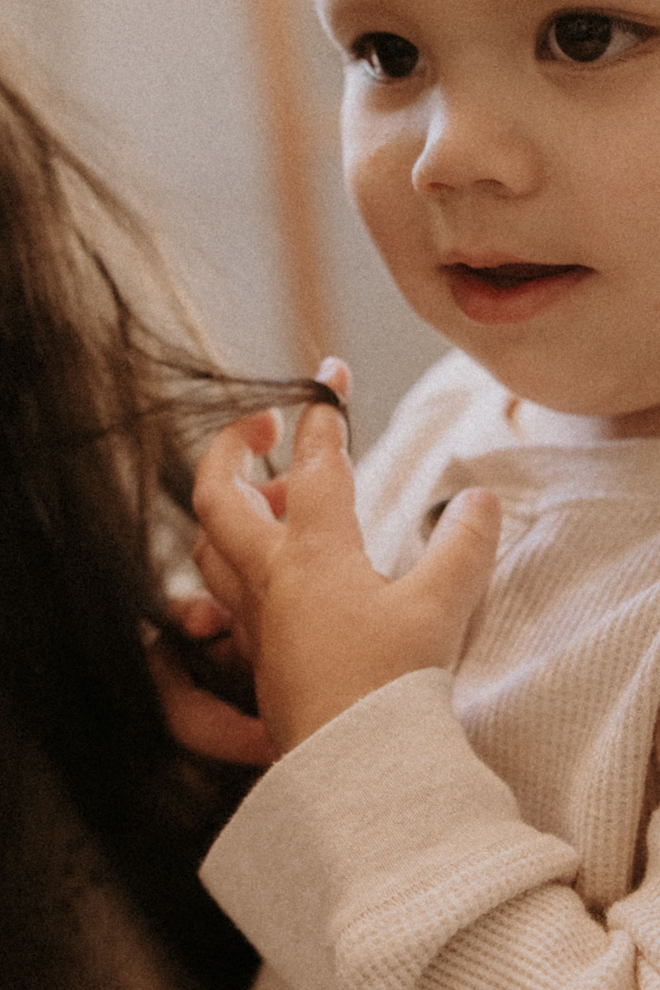 Close-up series of someone applying moisturizing cream to their face in a soft, warm light setting.