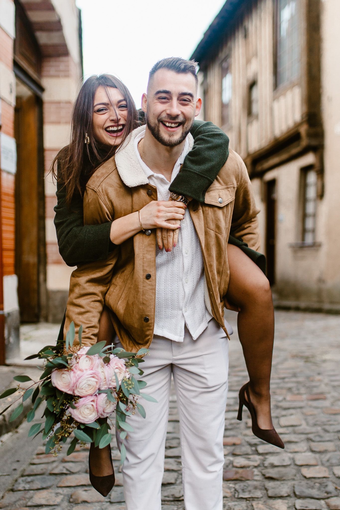 Photo romantique d'un couple complice en train de rire dans une ruelle charmante du village de Montfort-l'Amaury
