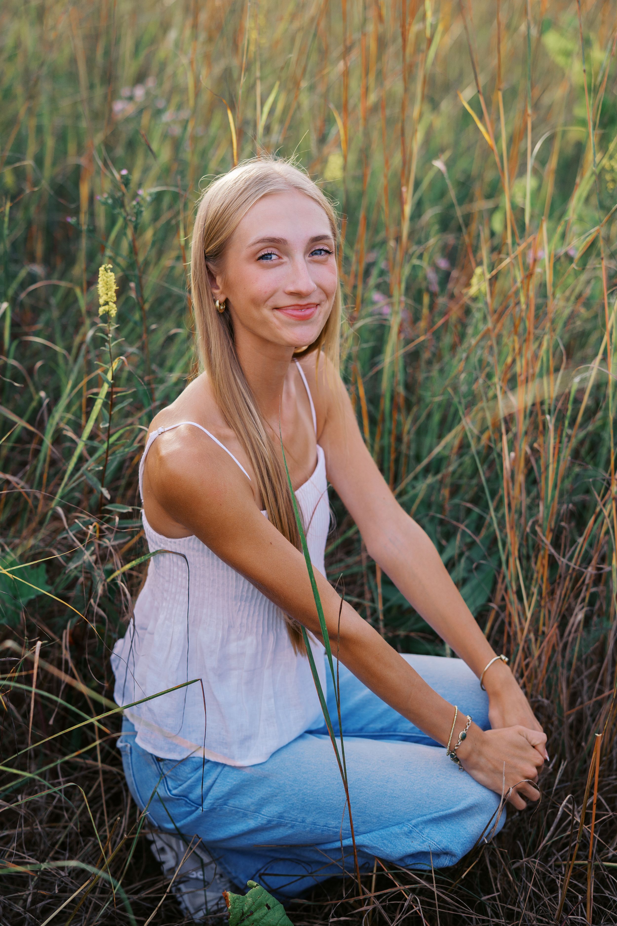 Casual poses captured in golden hour light among tall prairie grass.