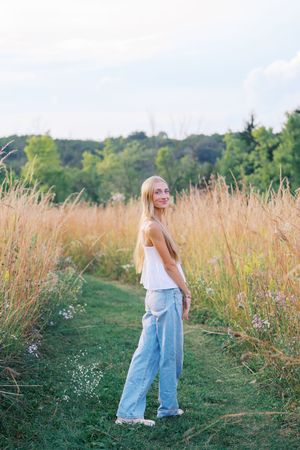 Natural lifestyle photography in an open field with a mowed path through tall grass.