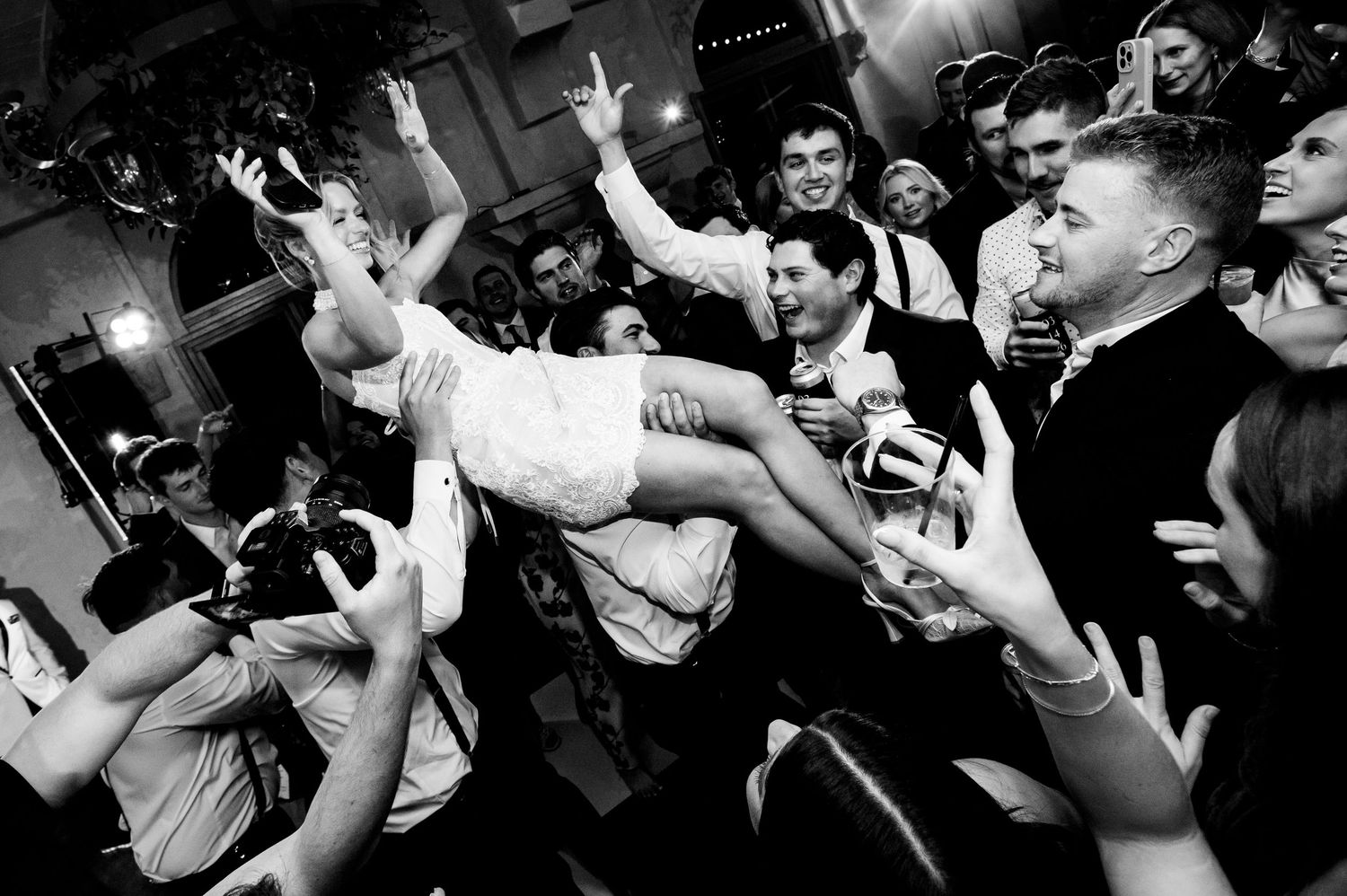 Energetic crowd at a punk rock concert with moshing fans and raised hands in a dark reception hall at Villa Antonia.