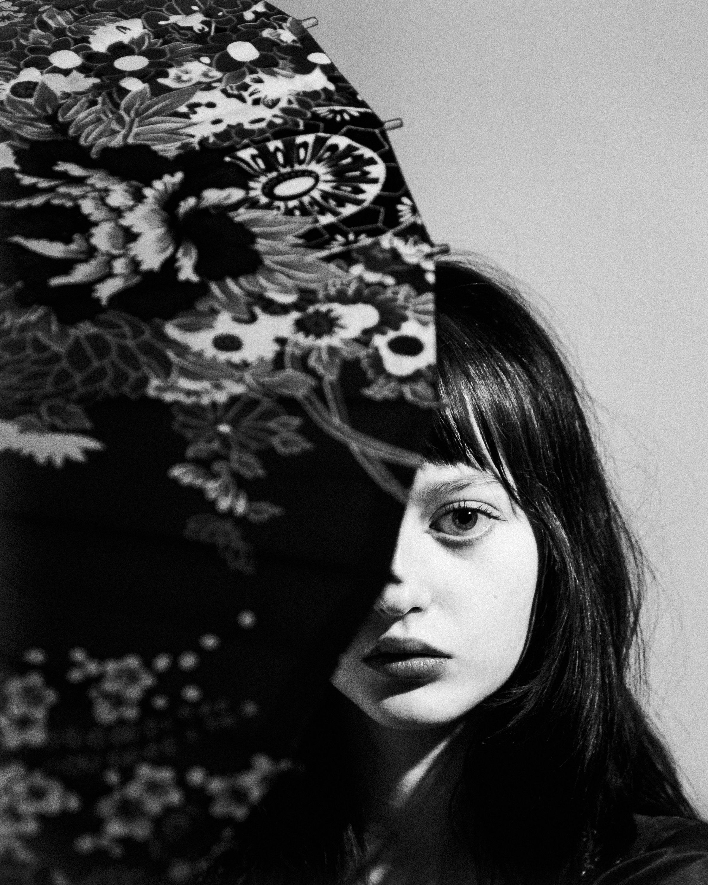 Black and white artistic portrait with shadows and floral patterns creating a dramatic contrast.
