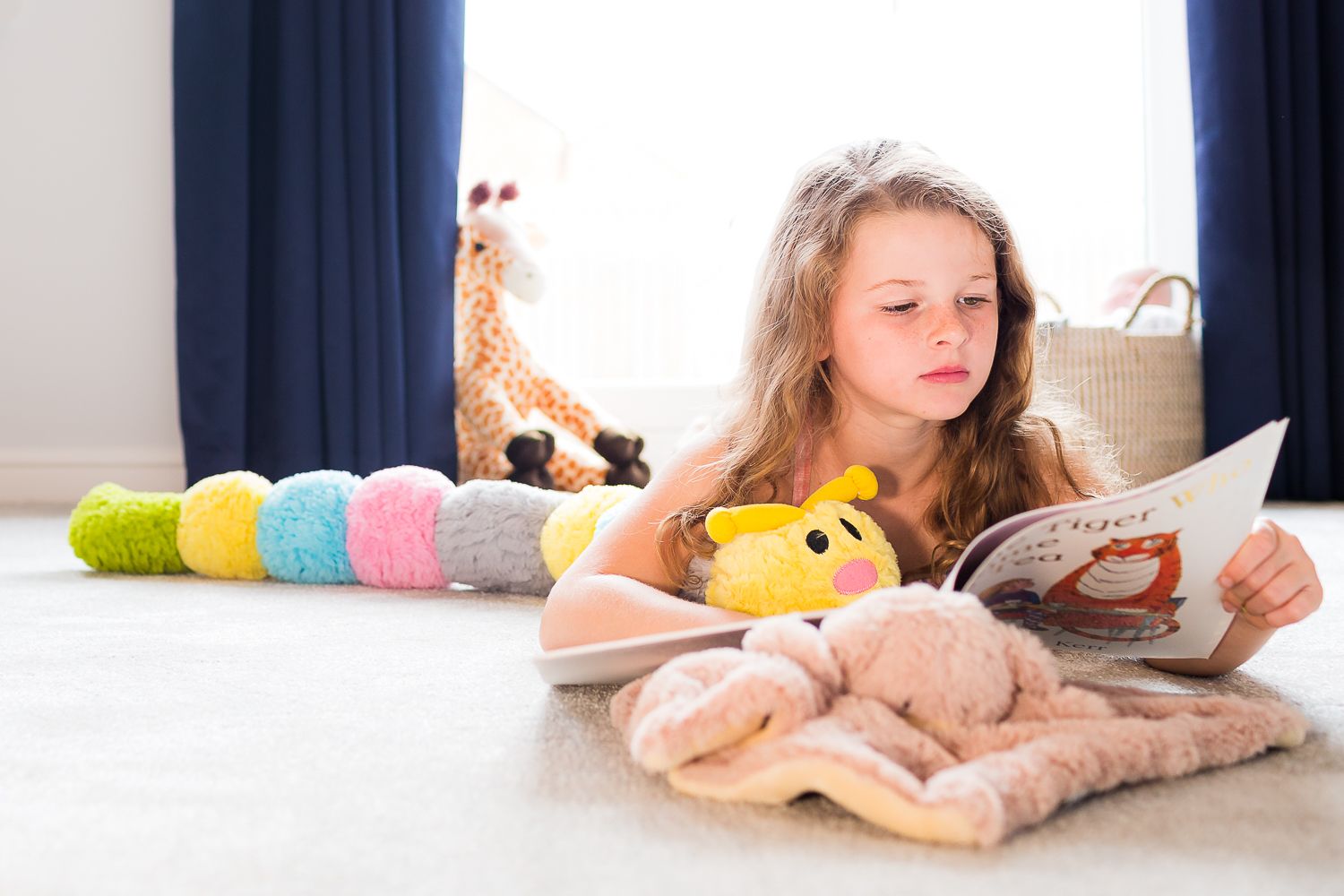 Reading time with stuffed animals and books on a cozy floor.
