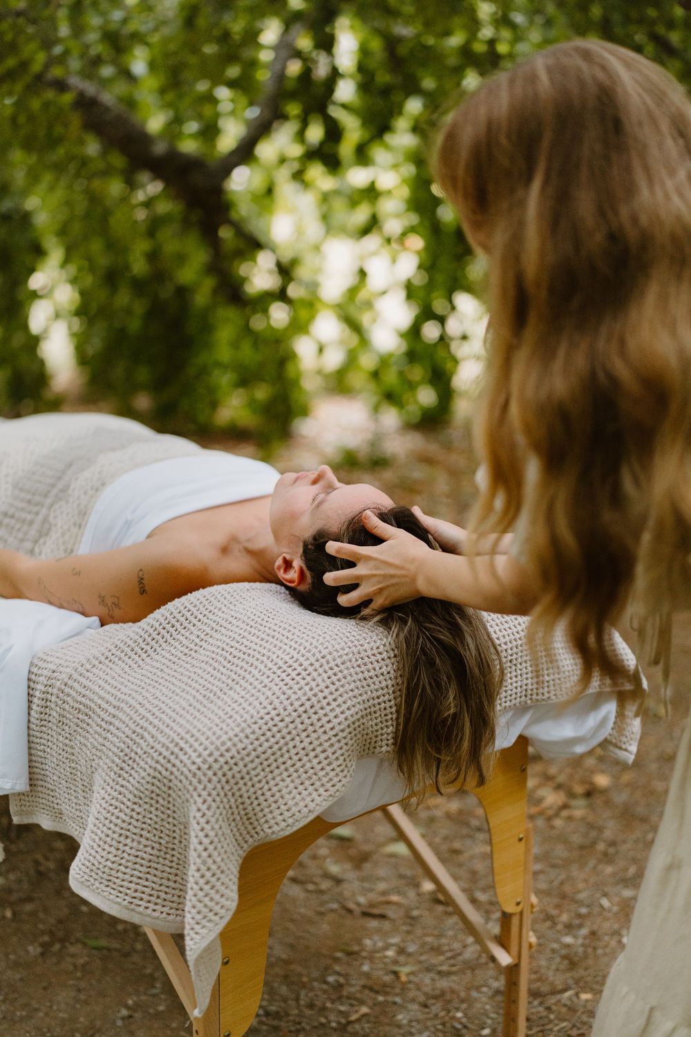 A series of photos showing a relaxation massage treatment being performed on a person lying on a wooden chair outdoors.