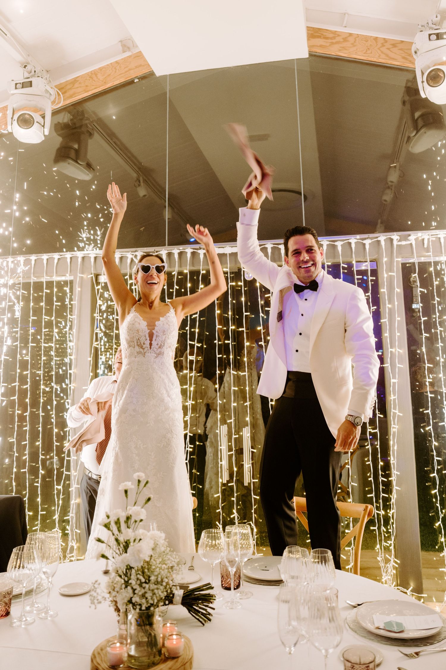 Bride and groom celebrate grand entrance with sparklers at elegant wedding reception.