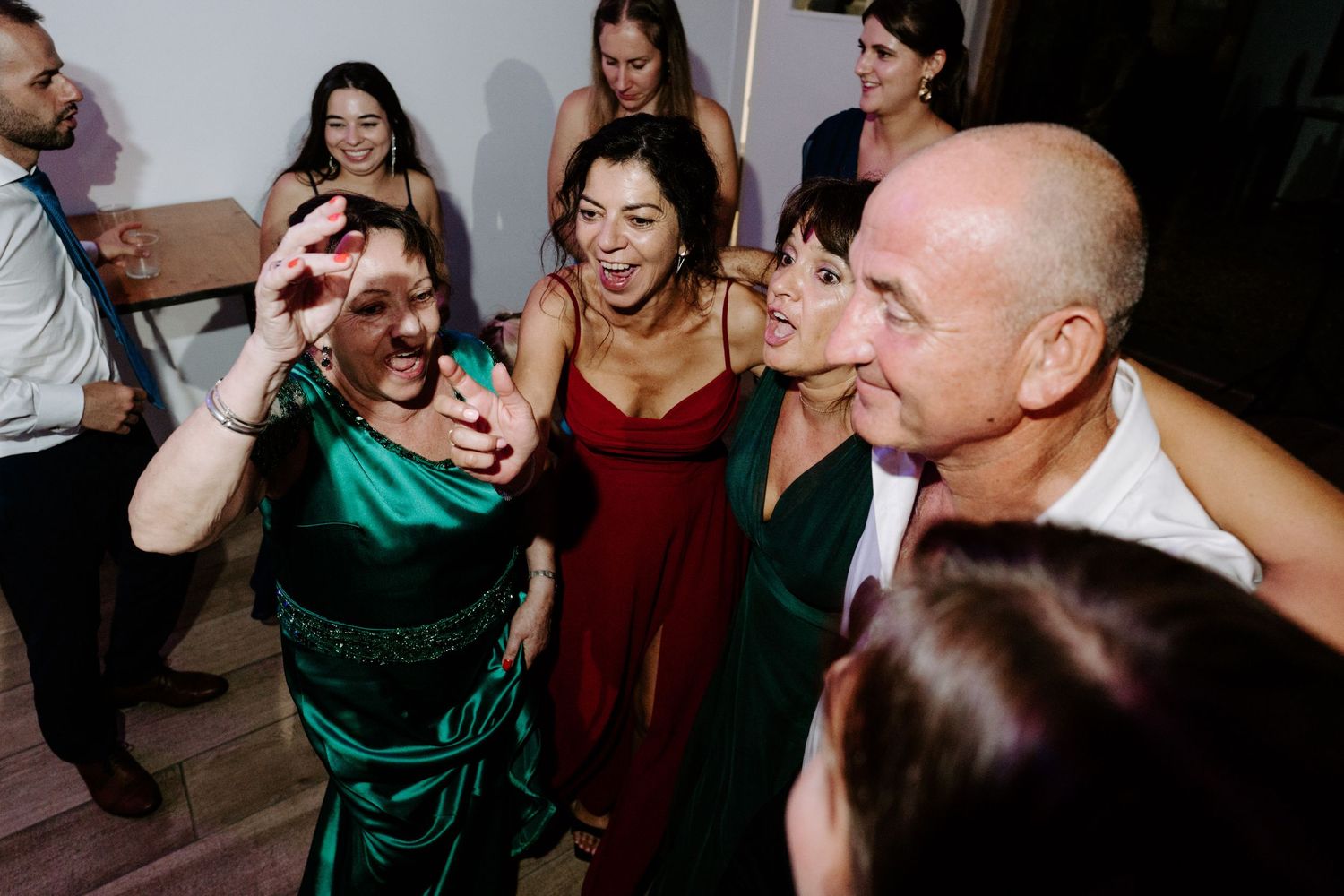 Group of wedding guests taking a selfie together on the dance floor at a festive reception.
