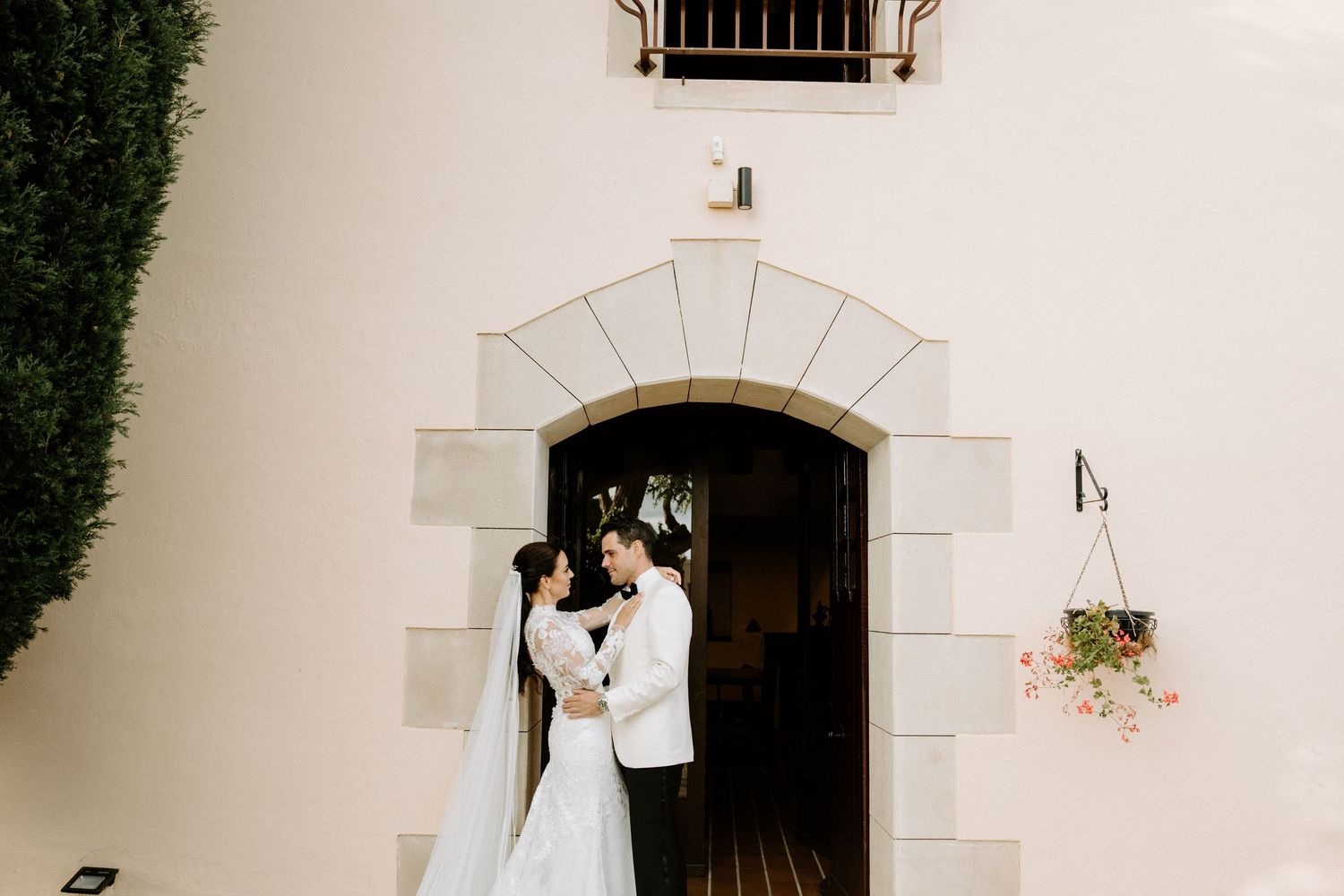 Bride and groom sharing romantic moment in front of elegant stone archway.