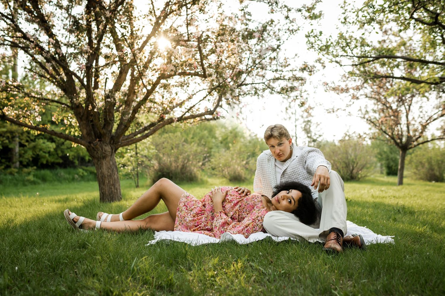 Beautiful golden hour maternity photos in Calgary springtime cherry blossoms by Calgary lifestyle photographer.