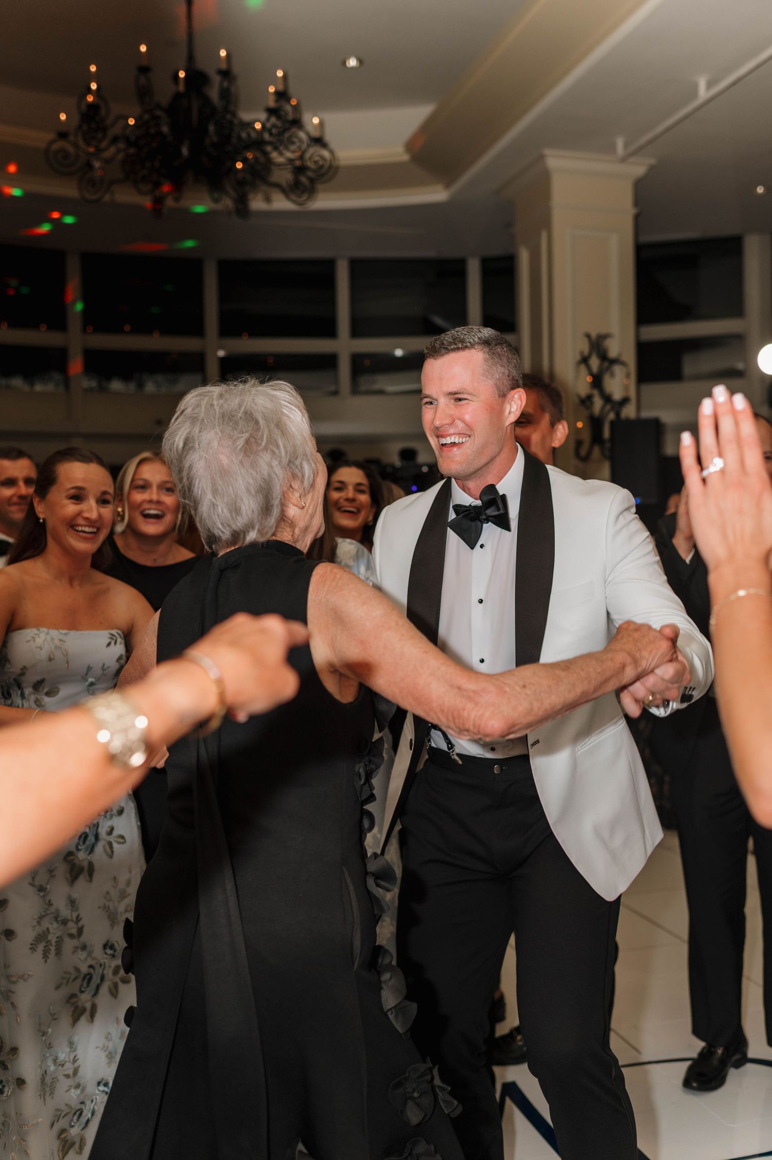 Wedding guests dancing and celebrating together on the dance floor at an elegant formal reception.