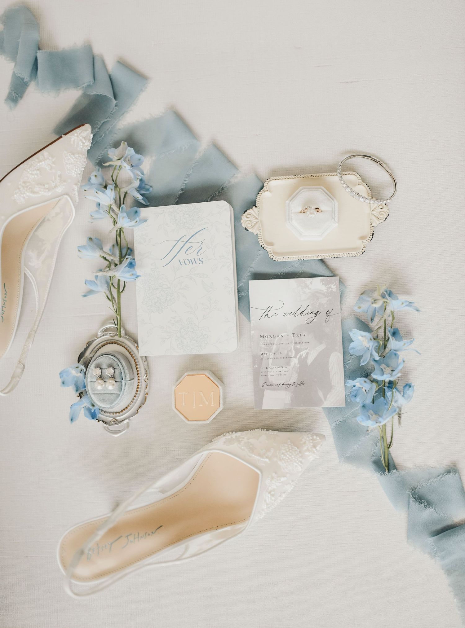 dusty blue and ivory wedding flat lay at The Gardenia venue with romantic styling