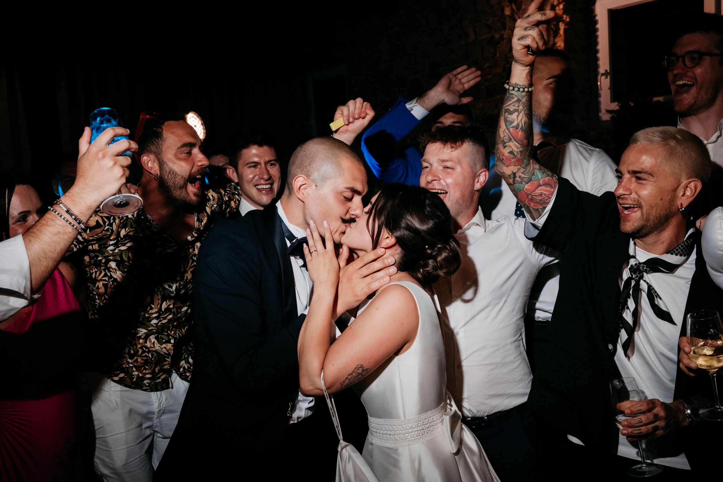 Lively wedding reception party with guests dancing and celebrating in formal attire.