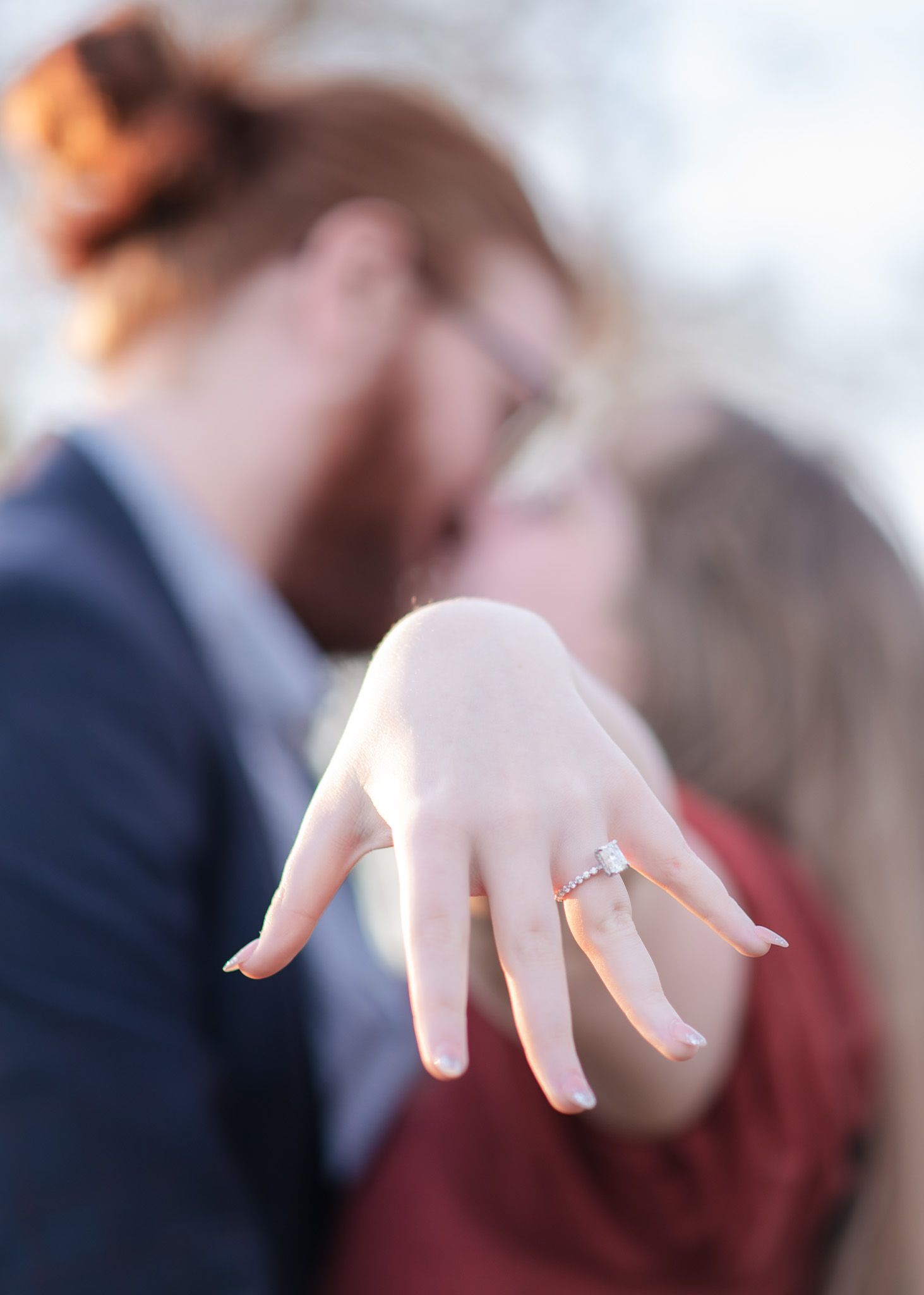 Engagement ring detail shot with newly engaged couple in background at Crossroads Park Temple Texas proposal session