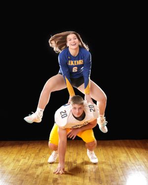 Female Vikings volleyball player leaps over crouching male Minneota football player number 20.