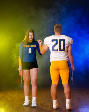 Female Vikings volleyball player and male football player number 20 pose back to back.