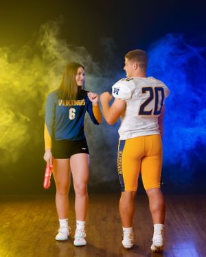 Minneota Vikings football and volleyball athletes in blue and gold uniforms fist bumping.