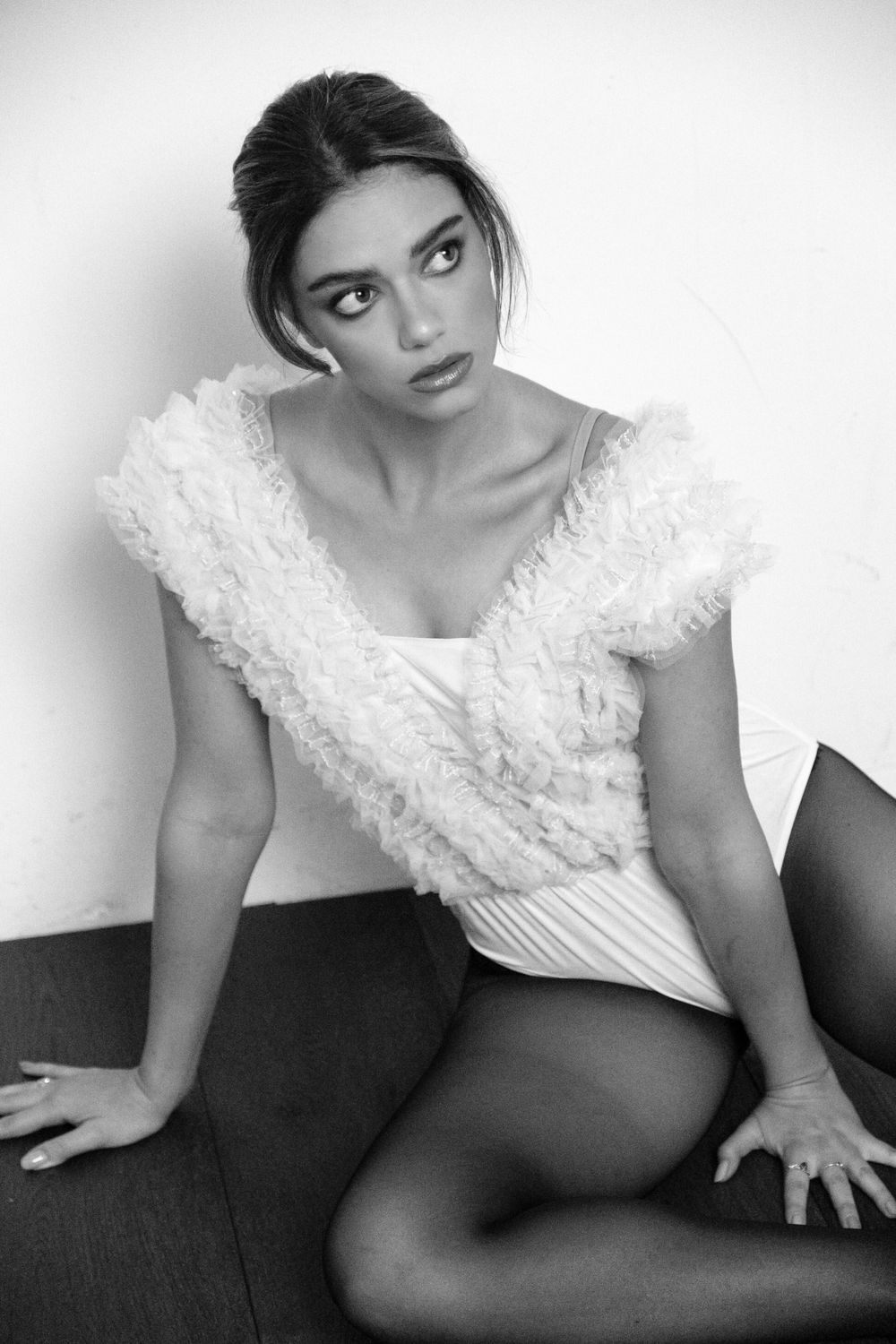 Artistic black and white portrait series showing a white lace top against dark background.