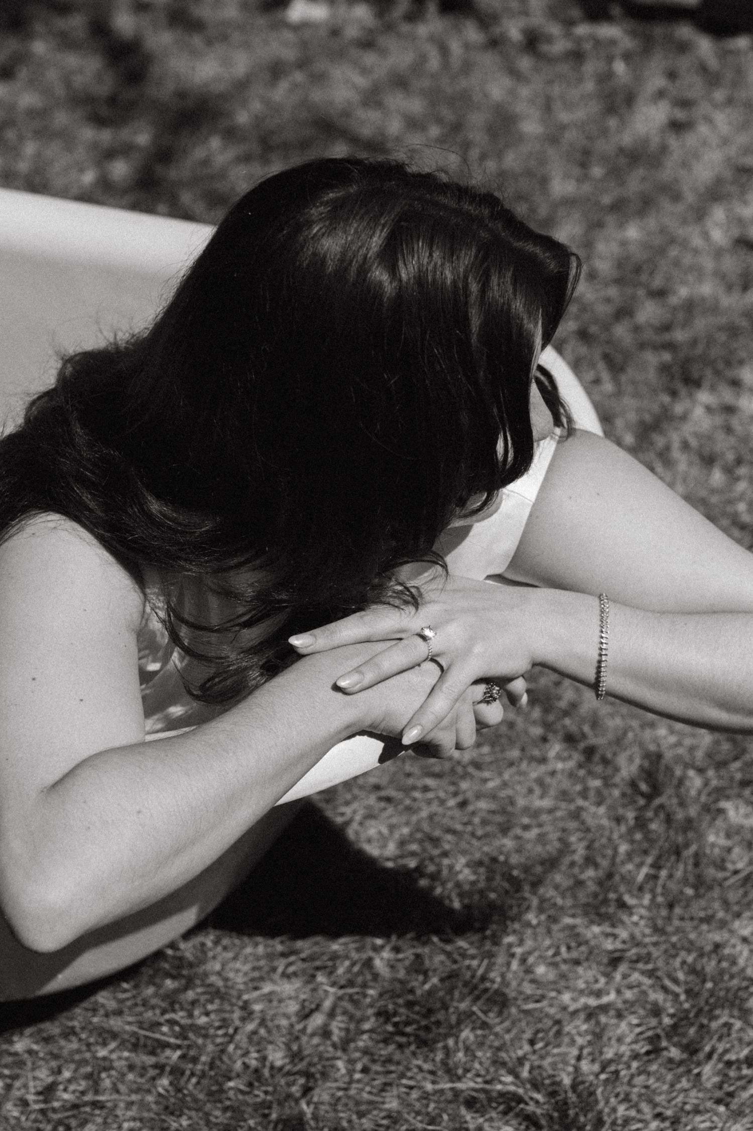 An artistic black and white photo of someone resting on a surface outdoors.