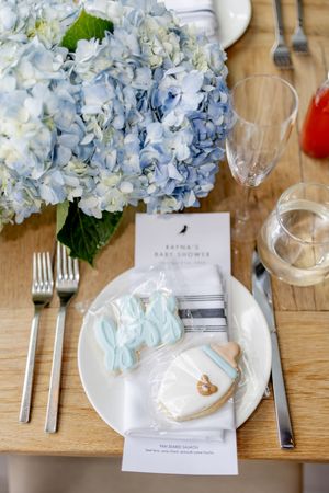 Blue hydrangea centerpiece at a baby shower table setting with decorated cookies and elegant place settings at the W Hotel in Hoboken, NJ.