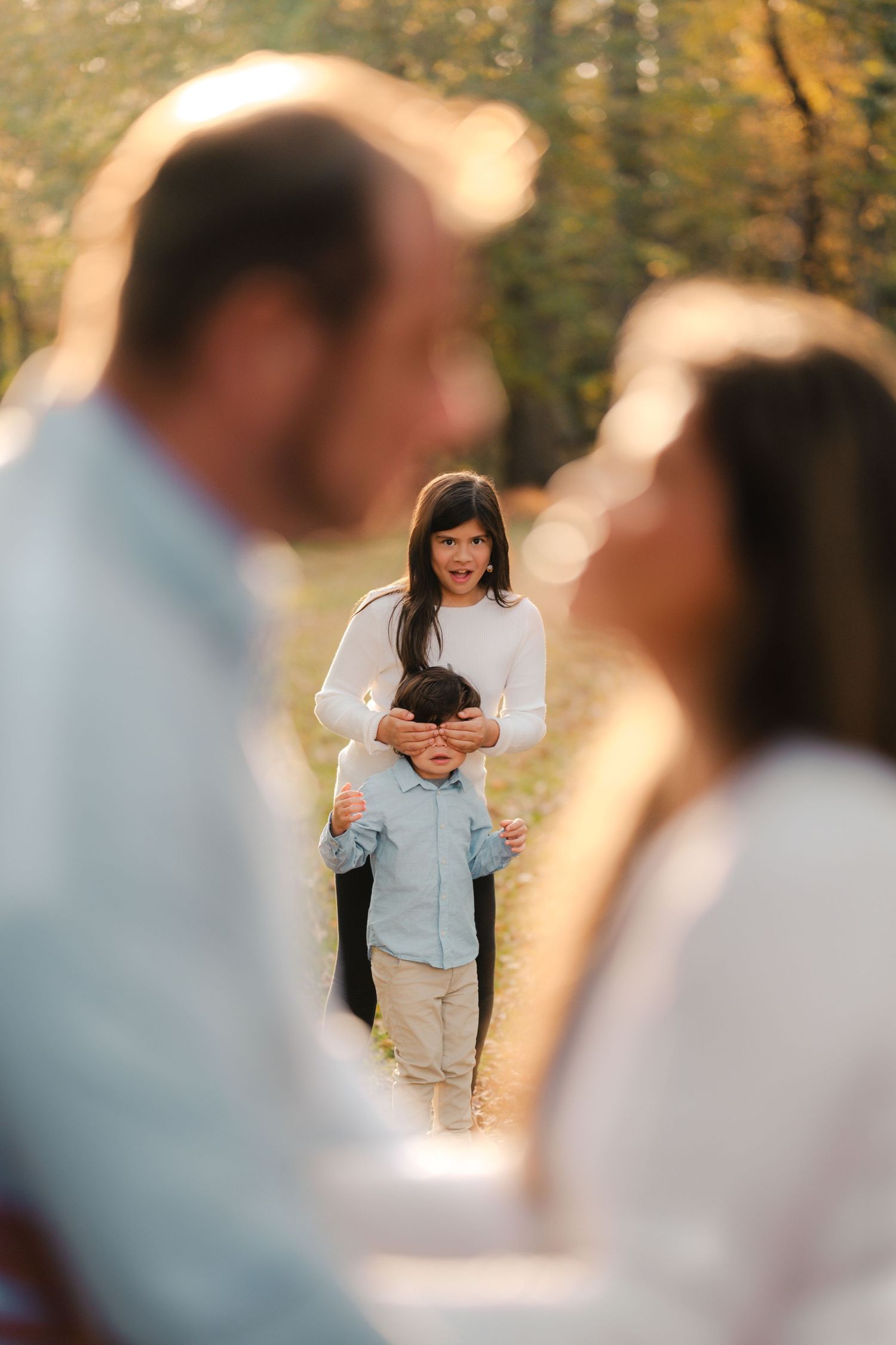 A couple shares an intimate outdoor moment during a golden hour photoshoot in a park setting.