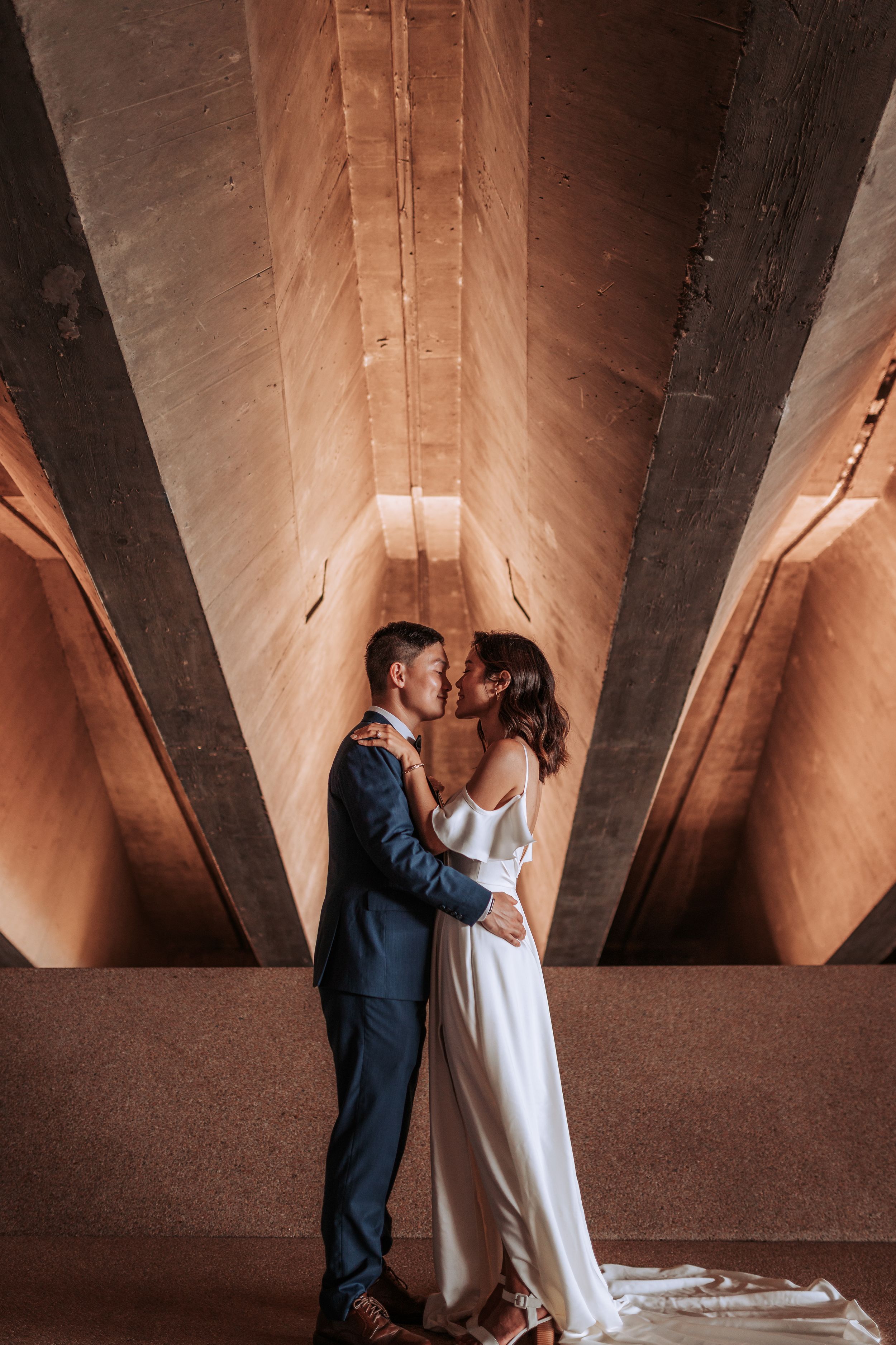 A romantic moment captured under dramatic architectural lighting and angles.
